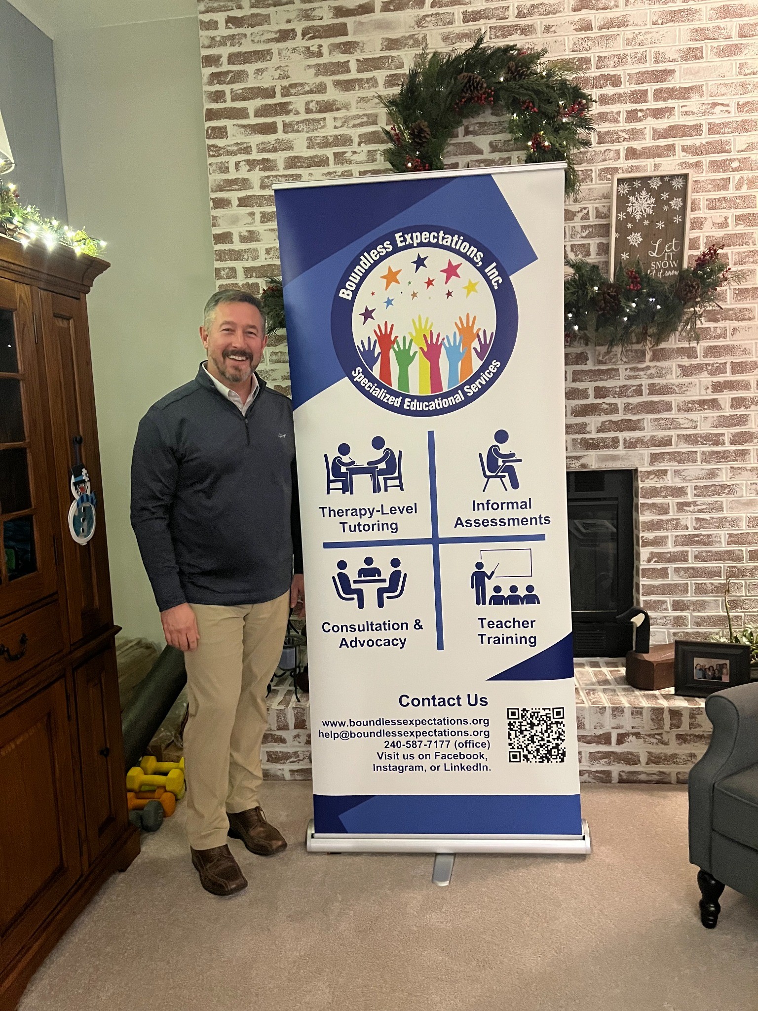BEI board member Don standing beside the Boundless Expectations community banner