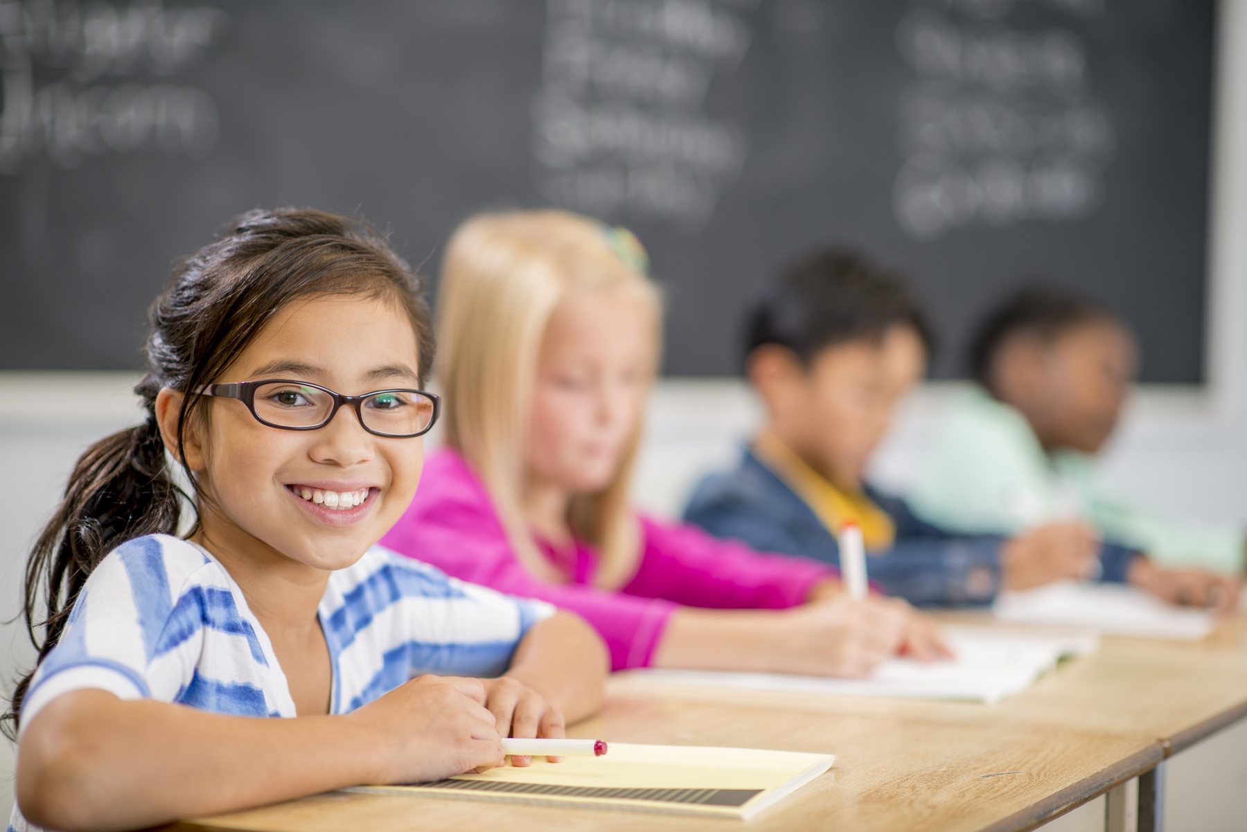 A young student enjoying a book in a classroom